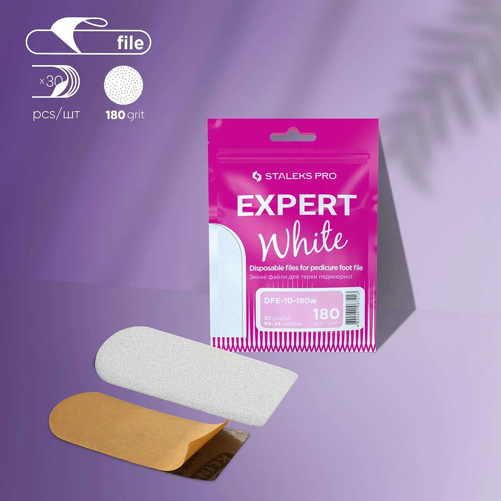 A package of Staleks STALEKS PRO Refill Pads for Pedicure Foot File Expert 10 (180 grit) is displayed with two disposable pads—one with backing, one without—set against a purple background with a leaf shadow.