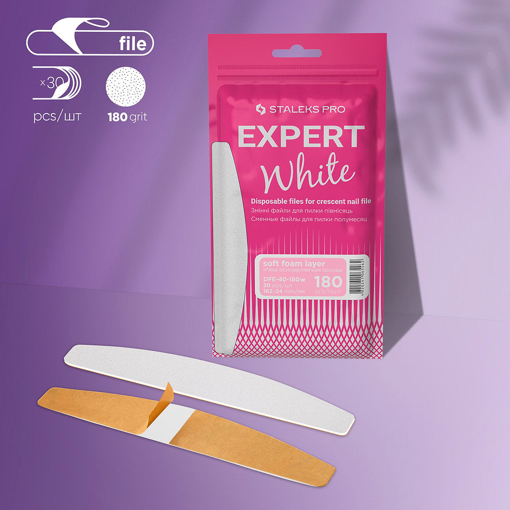A pink package labeled "STALEKS PRO EXPERT 40" contains 30 disposable white crescent nail files with a soft foam layer and adhesive backing. The packaging notes "180 grit," "3 pcs," and is shown on a purple background. Brand: Staleks.