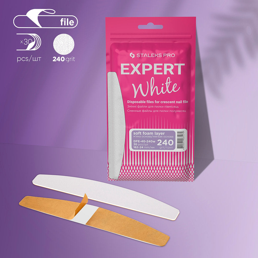 The STALEKS PRO EXPERT 40 pack contains 30 crescent-shaped disposable white files with soft foam, ideal for artificial nails. Shown are two files, one partly in brown paper. The pink and white package highlights "240 grit." Brand: Staleks.