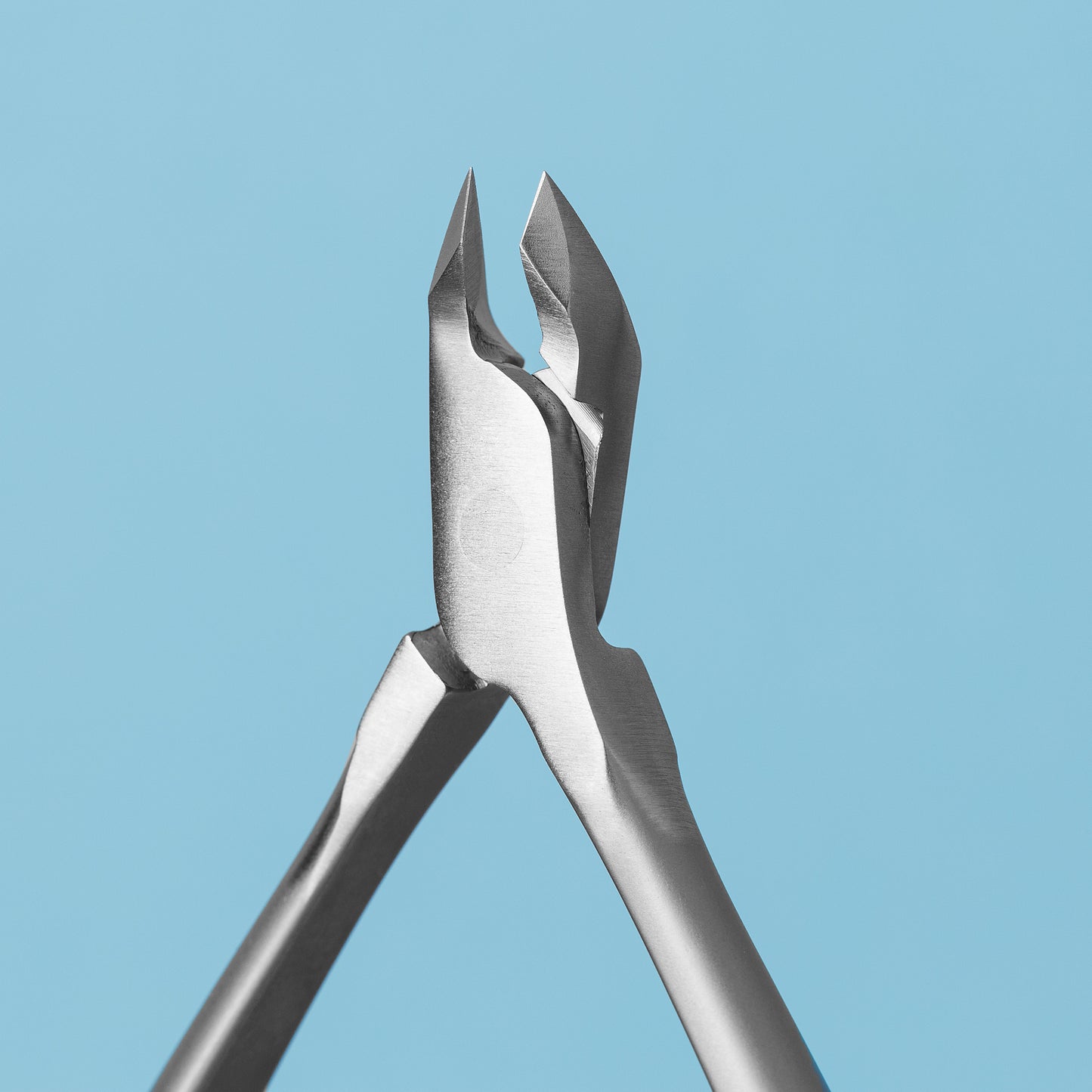 Close-up of a STALEKS PRO Professional Cuticle Nippers 4 mm jaw SMART 30 by Staleks on a light blue background. The open blades display their sharp, precise edges, expertly crafted for accurate trimming like professional nippers.