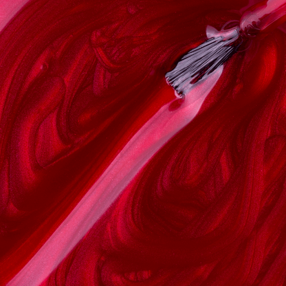 A close-up of a brush applying Impala Regular Nail Polish Pearlescent Red Amante Perolado 7.5 ml, creating smooth, swirling patterns in the rich, vibrant color.