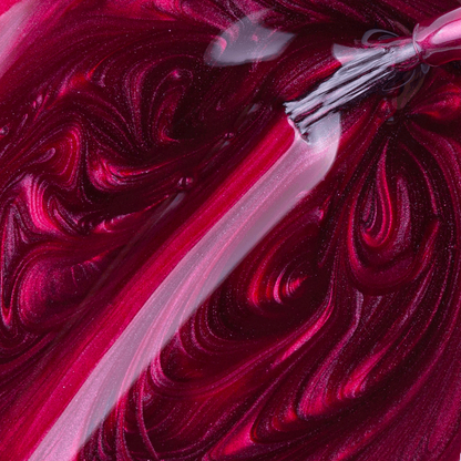 A close-up of an Impala brush applying shiny, pearlescent red Amor Perolado nail polish, swirling with metallic shimmer; the brush glides on a smooth streak through the richly textured, long-lasting 7.5 ml formula.