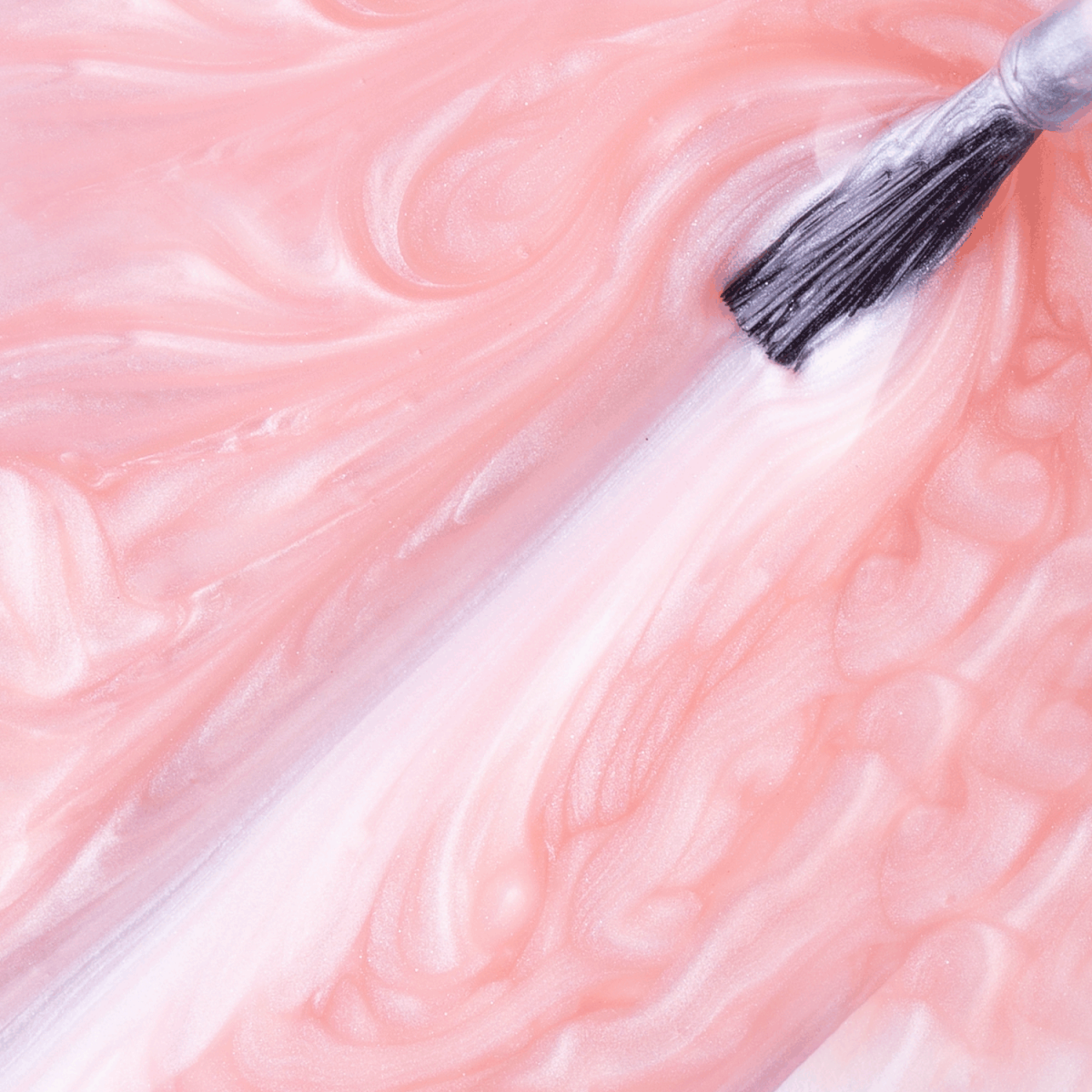 A paintbrush glides pearlescent pink Impala Regular Nail Polish Soft Rosé Dengo Perolado 7.5 ml across a surface, creating smooth, glossy strokes with its creamy texture.