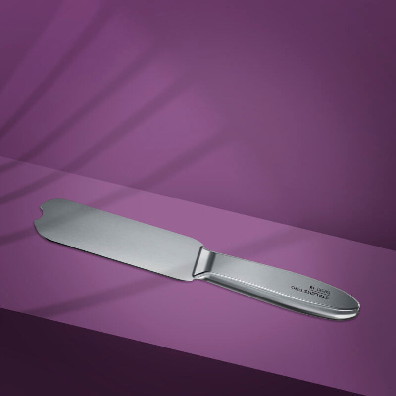 The STALEKS PRO Metal Base for Pedicure Grater EXPERT 10 by Staleks, made of stainless steel, rests on a purple surface with its rounded edge and slight notch casting a subtle shadow.