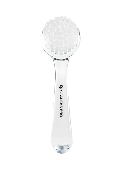 The STALEKS PRO Manicure Brush EXPERT 01 for Dust Removal features a clear handle, dense synthetic bristles, a protective cover, and "Staleks" branding on the handle, displayed against a black background.