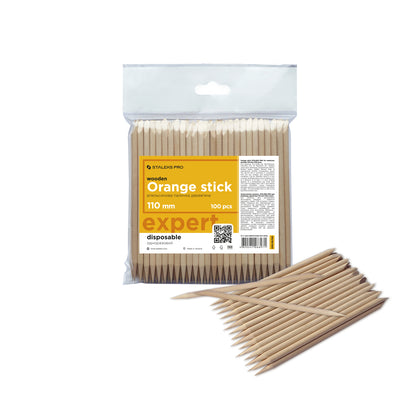 A package of 100 Staleks PRO Orange sticks for manicure wooden 110 mm in length, displayed alongside a loose arrangement of several sticks outside the package.