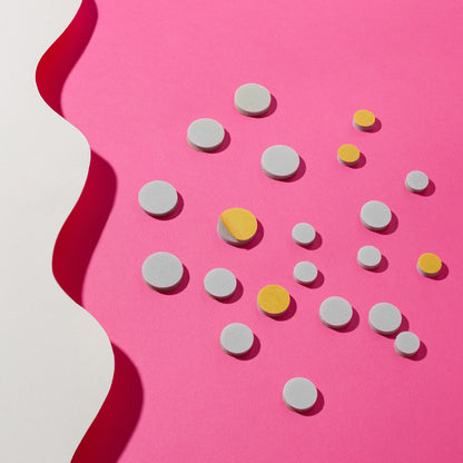 Staleks STALEKS PRO Disposable Files for Pedicure Disc PODODISC L EXPERT (25mm, 50pcs), gray and yellow, are arranged on a vivid pink background beside an uneven white border, forming a striking abstract visual.