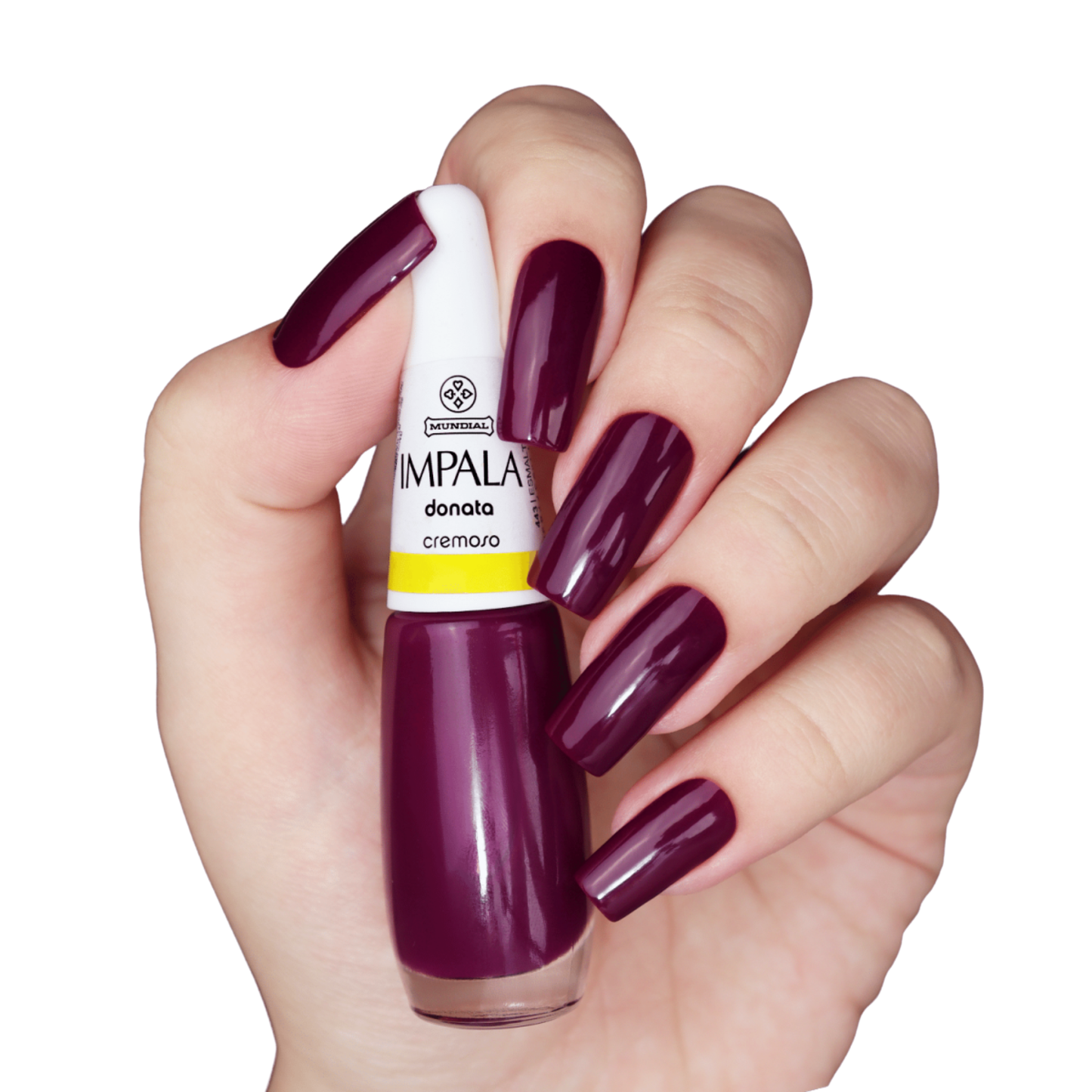 A hand with long, square nails painted in deep wine purple holds a 7.5 ml bottle of IMPALA Regular Nail Polish Creamy Wine Purple Donata by Impala, matching the shade perfectly.