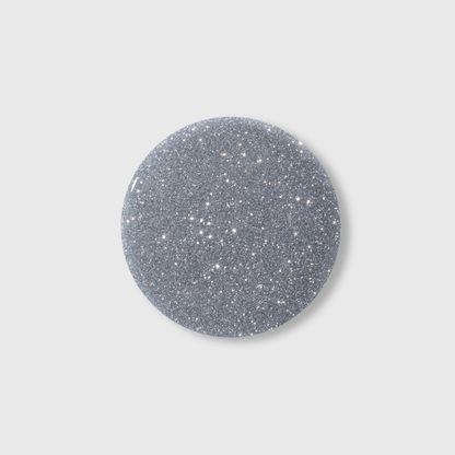 A round, silver glittery object on a plain light gray background, reminiscent of the dazzling luminous effect produced by Lumore’s LUMORE PARIS Reflective Gel Polish in the shade Margarita (9 ml), capturing the brilliance of modern nail art designs.
