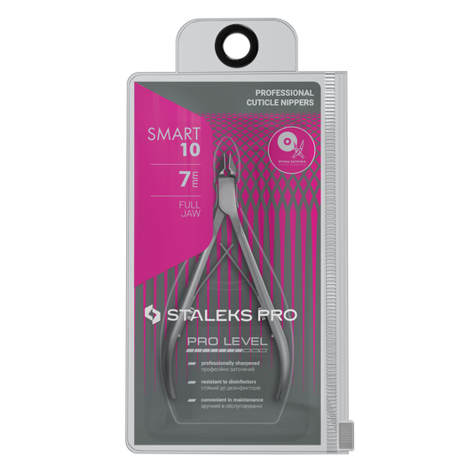 A package of Staleks STALEKS PRO Professional Cuticle Nippers SMART 10 4 mm, a stainless steel manicure tool, features a clear front displaying the nippers and a pink geometric design with product details on the packaging.
