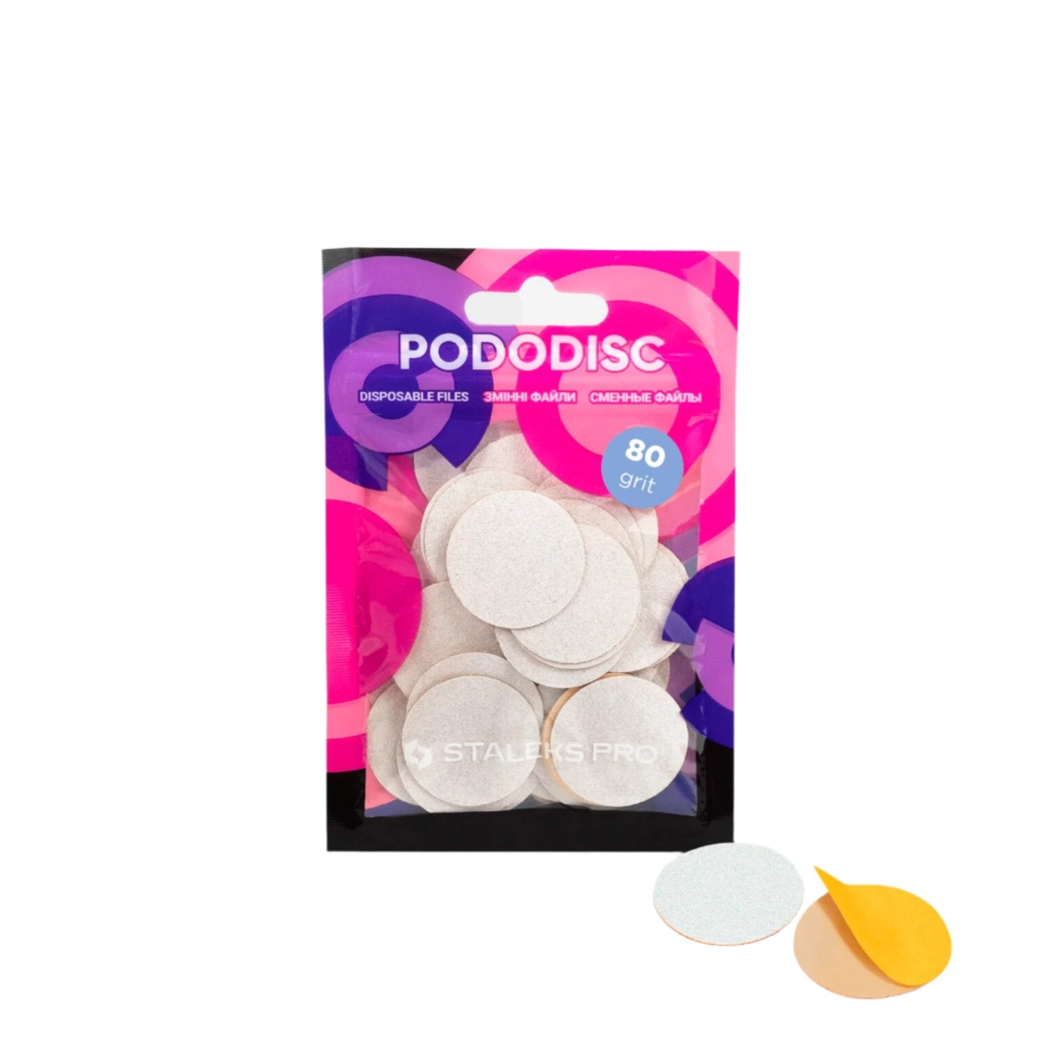 A package of STALEKS PRO Disposable files for pedicure disc PODODISC L EXPERT (25mm) / 50pcs by Staleks is shown with several round, white abrasive discs (80 grit), one displaying its adhesive backing. The packaging has pink, purple, and black colors.