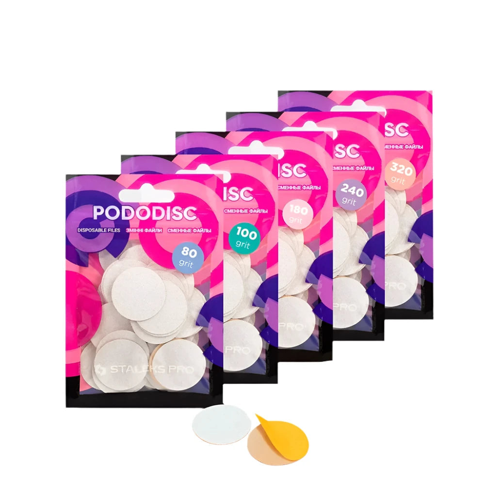 Five packets of Staleks STALEKS PRO Disposable files for pedicure disc PODODISC L EXPERT (25mm, 50pcs) in grits 80, 100, 180, 240, and 320 are arranged in a row, with two individual discs displayed in front.