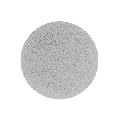 A perfectly round, flat STALEKS PRO Disposable File-Sponge for Pedicure Disc PODODISC M EXPERT 20 (25 pcs) by Staleks in light gray, with a smooth, slightly speckled abrasive surface, is centered on a solid black background.