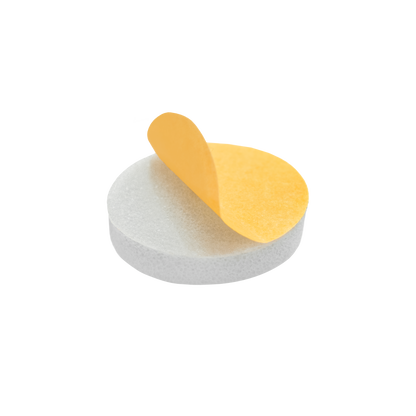 The Staleks PRO Disposable Files-Sponges for Pedicure Disc PODODISC L EXPERT 25 (25 pcs) feature a round white foam pad with a yellow peel-off backing, revealing an adhesive side for easy, effective foot smoothing.