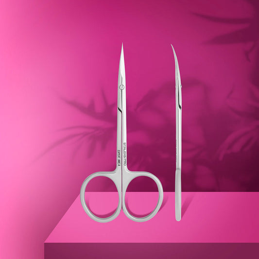 Two pairs of Staleks STALEKS PRO Professional Cuticle Scissors EXPERT 50 TYPE 3 stand upright on a pink surface with leaf shadows against a pink background.