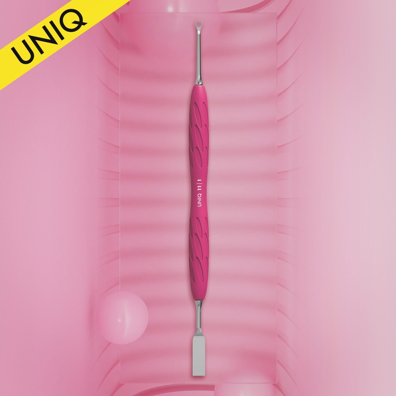 A pink and silver STALEKS PRO Gummy Manicure Pusher with Silicone Handle UNIQ 11 TYPE 1 is centered against a gradient pink background. This beauty tool, designed by Staleks, showcases a textured grip with a flat straight pusher on one end and a ring on the opposite end, making it perfect for professional manicure pedicures. A yellow "UNIQ" label adorns the top left corner.
