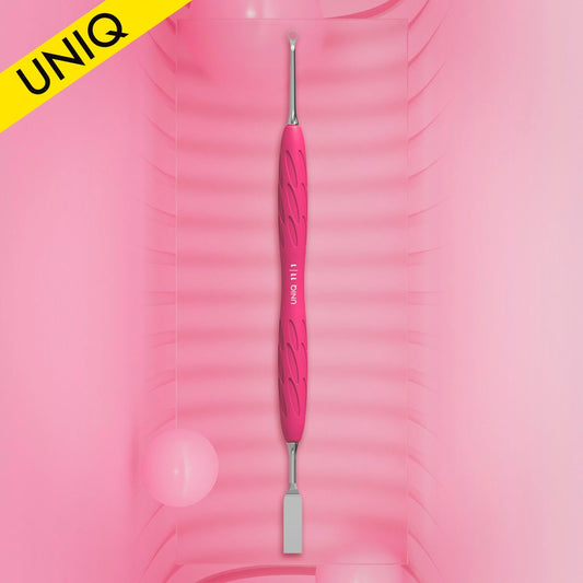A pink and silver STALEKS PRO Gummy Manicure Pusher with Silicone Handle UNIQ 11 TYPE 1 is centered against a gradient pink background. This beauty tool, designed by Staleks, showcases a textured grip with a flat straight pusher on one end and a ring on the opposite end, making it perfect for professional manicure pedicures. A yellow "UNIQ" label adorns the top left corner.
