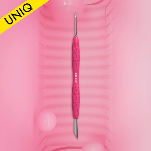 Centered on a pink background with subtle diagonal lines is the STALEKS PRO Gummy Manicure Pusher with Silicone Handle UNIQ 11 TYPE 2 from Staleks, showcasing expert craftsmanship. This dual-ended tool, perfect for manicures and pedicures, features a slanted pusher on one end and a ring on the other. A yellow banner displaying "UNIQ" decorates the top left corner.