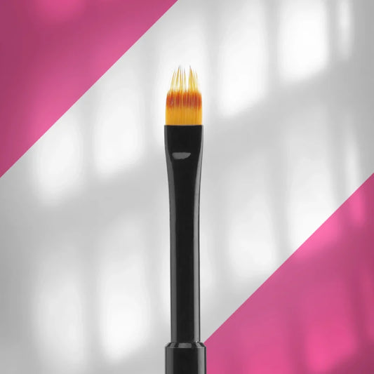 A close-up of the STALEKS PRO Brush For Gradient EXPERT (7 mm wide, 11 mm long) by Staleks, featuring yellow synthetic bristles and a black handle against a pink and white diagonal background—perfect for precise nail art.