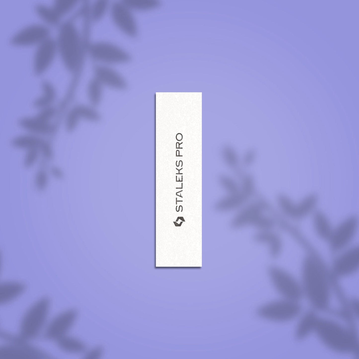 A white rectangular STALEKS PRO Grinding Buff EXPERT 51 150 grit nail file (10 pcs) with black vertical branding, displayed on a soft purple background with subtle blurred leaf shadows in the corners.