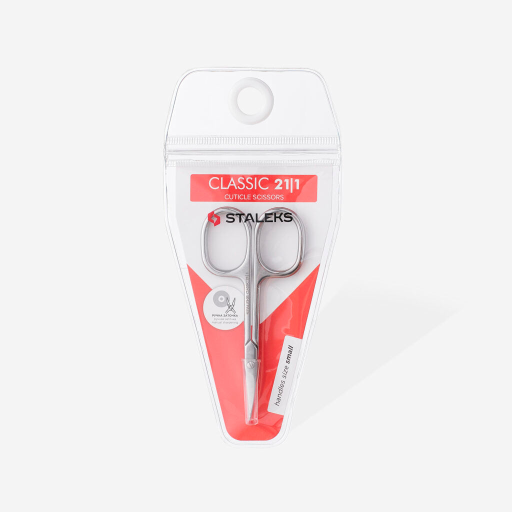 The STALEKS PRO Cuticle Scissors CLASSIC 21 TYPE 1 by Staleks come in clear plastic packaging with a red and white design, featuring precision icons—ideal for manicures and pedicures.