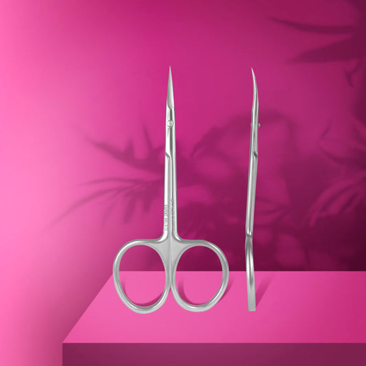 Staleks PRO Professional Cuticle Scissors EXPERT 20 TYPE 2 stand upright on a pink platform with soft leaf shadows in the background, showcasing their pointed high-alloy stainless steel blades.