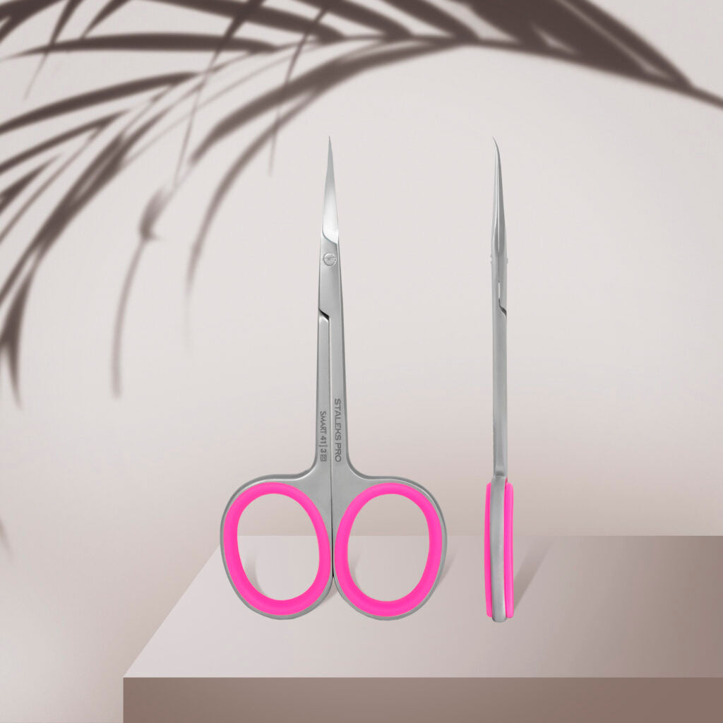 Staleks STALEKS PRO Professional Cuticle Scissors With Hook SMART 41 TYPE 3, featuring silver blades and pink handles with a curved hook design, are displayed front and side on a beige surface with a soft plant shadow in the background.